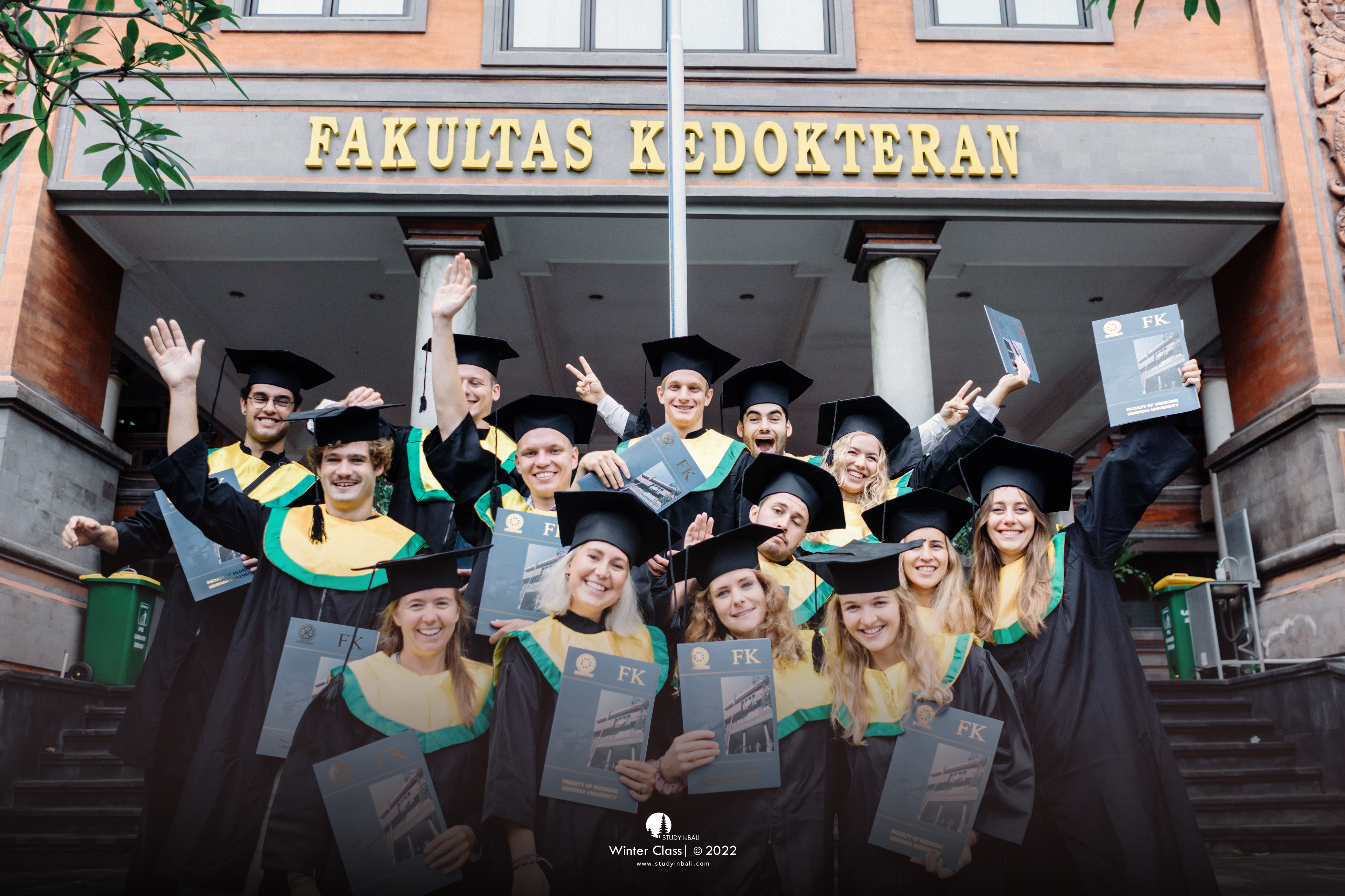 Graduating Sports and Physiotherapy students in front of the Medical Faculty building, holding their certificates