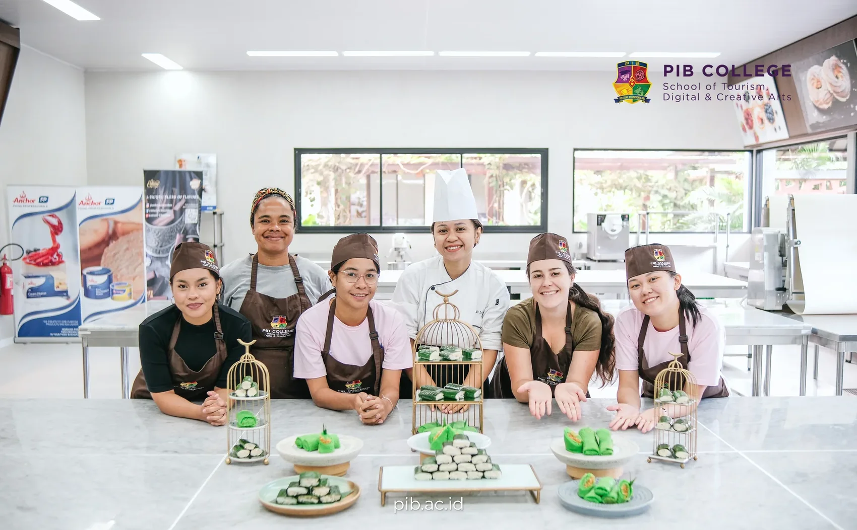 Six women posing behind a decorative display of green sweets