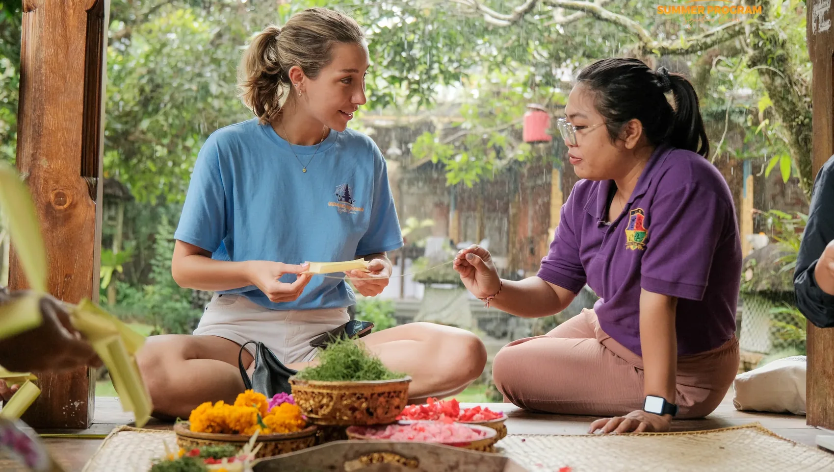 Local instructor teaching a student to make a Balinese flower offering