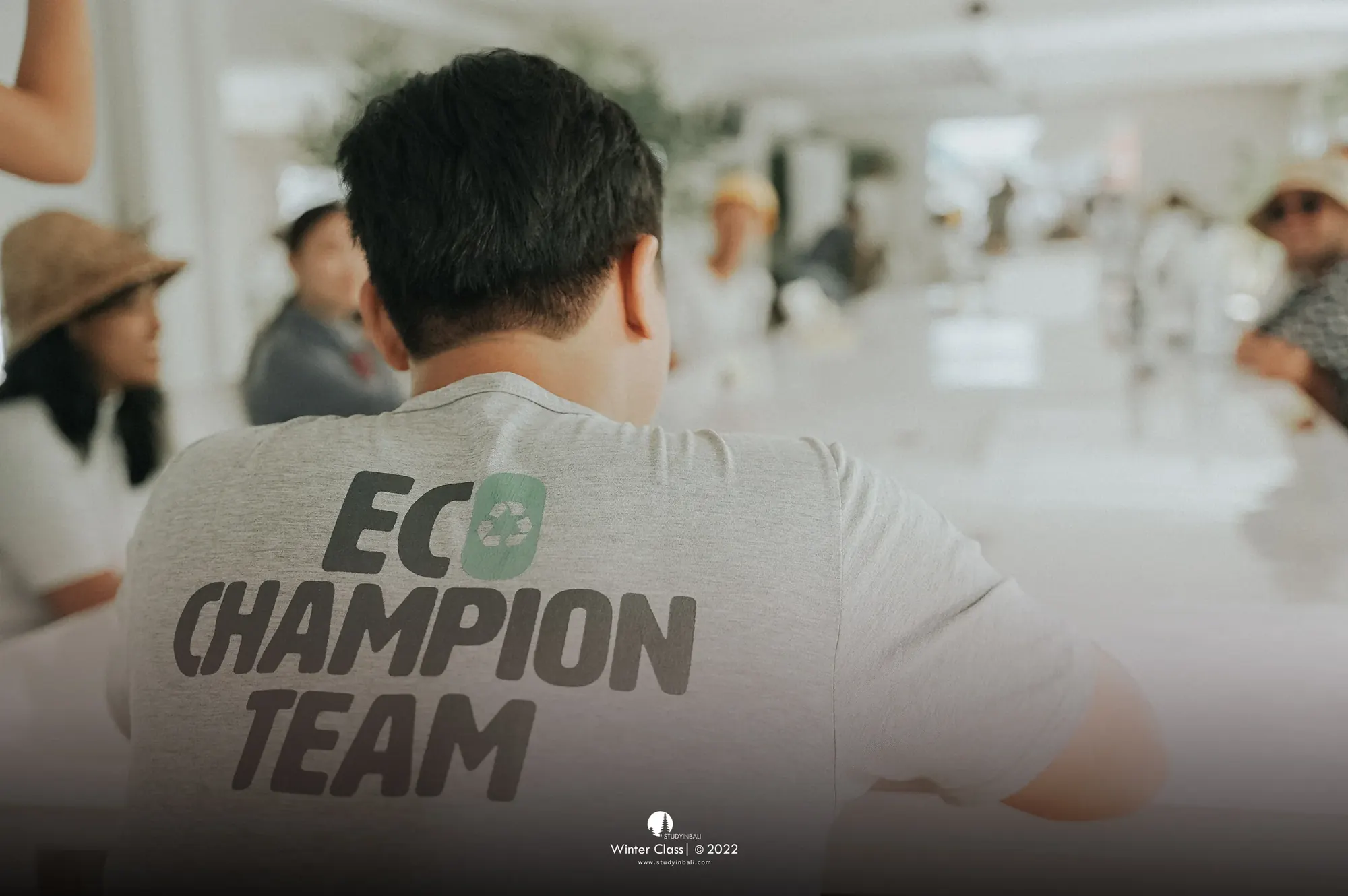 Students in a classroom session, one wearing an Eco Champion Team shirt