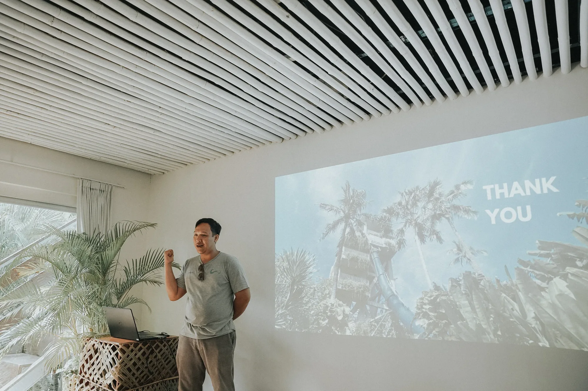 Presenter beside a thank-you slide at a workshop