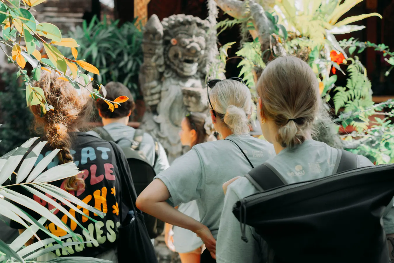 A group listening in a tropical garden