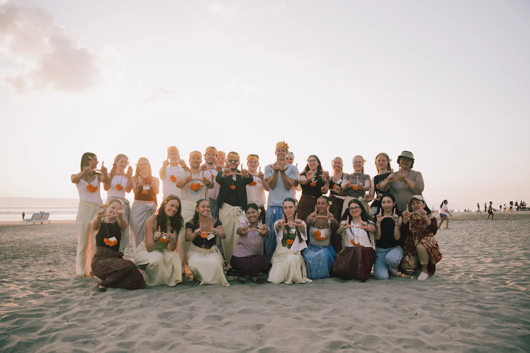 The Winter Class 2026 cohort at Universitas Udayana, posing on the beach at sunset after the Welcoming Dinner