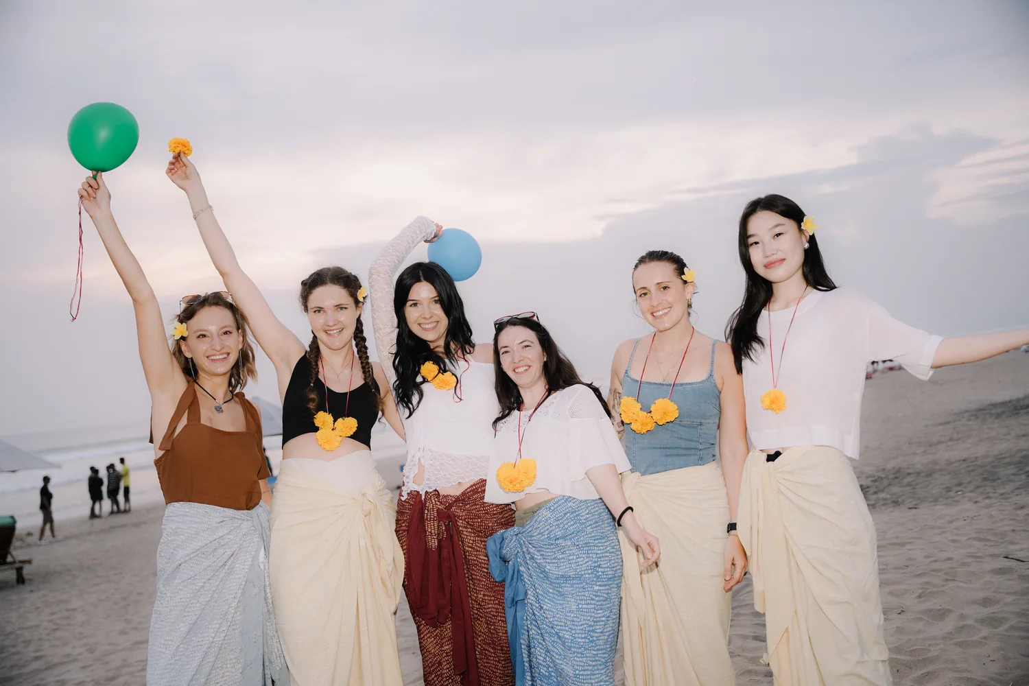 Students with flower garlands and balloons at the welcome dinner on the beach