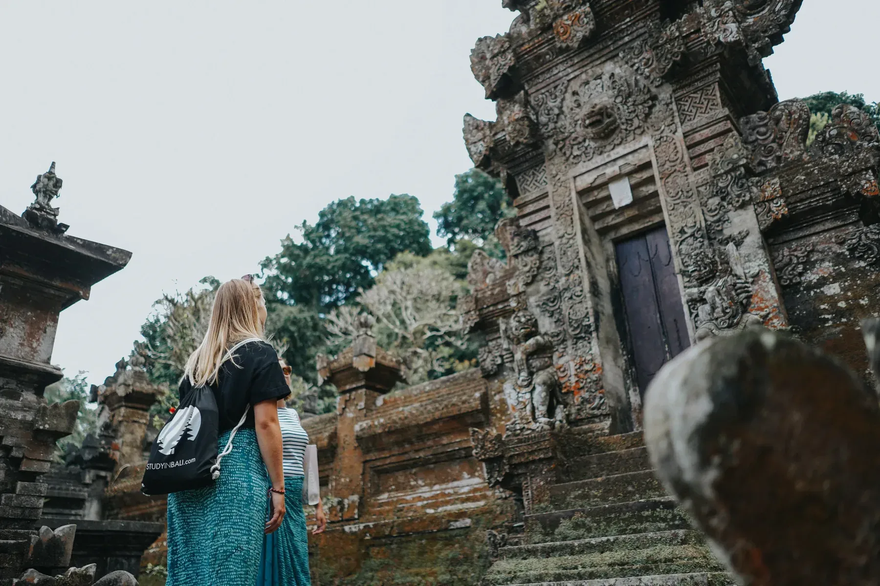 A student at a traditional Balinese temple gate