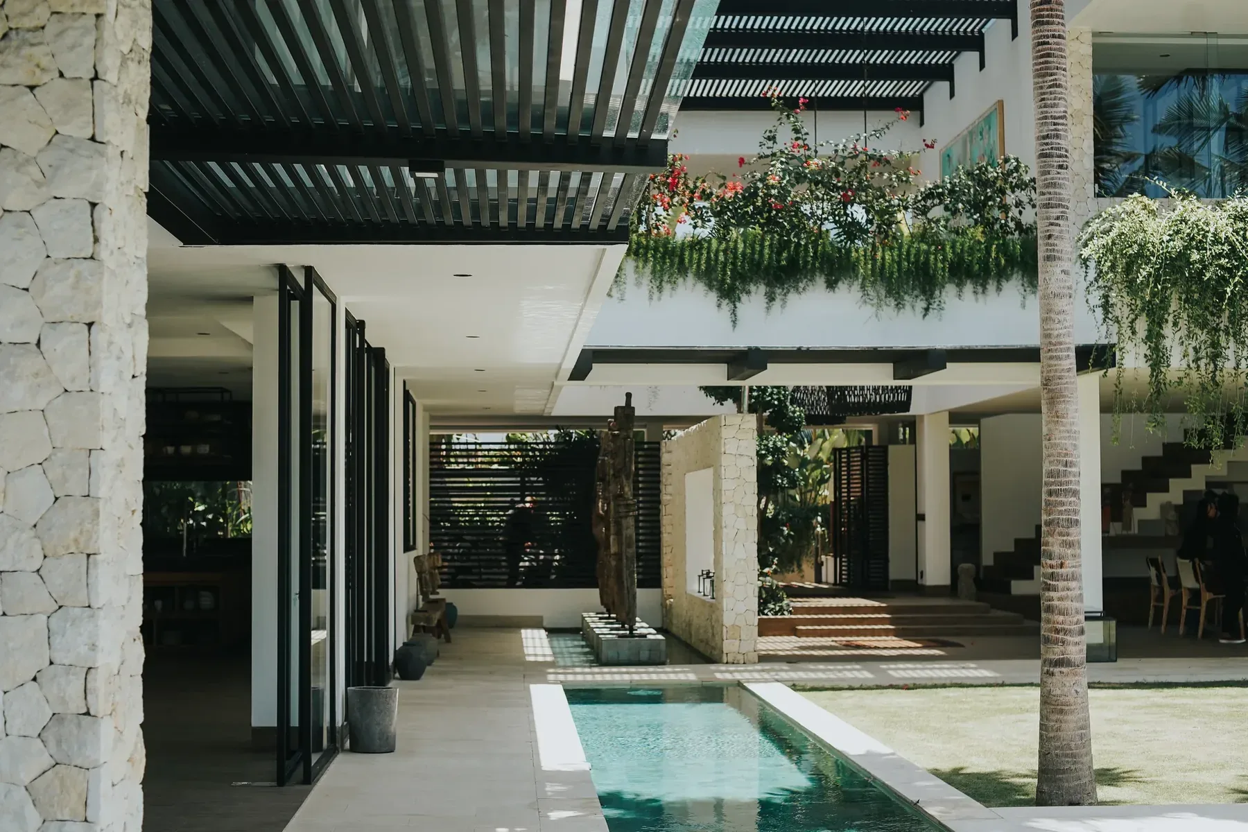 A contemporary tropical building in Bali with an open plan, louvred roof and courtyard pool