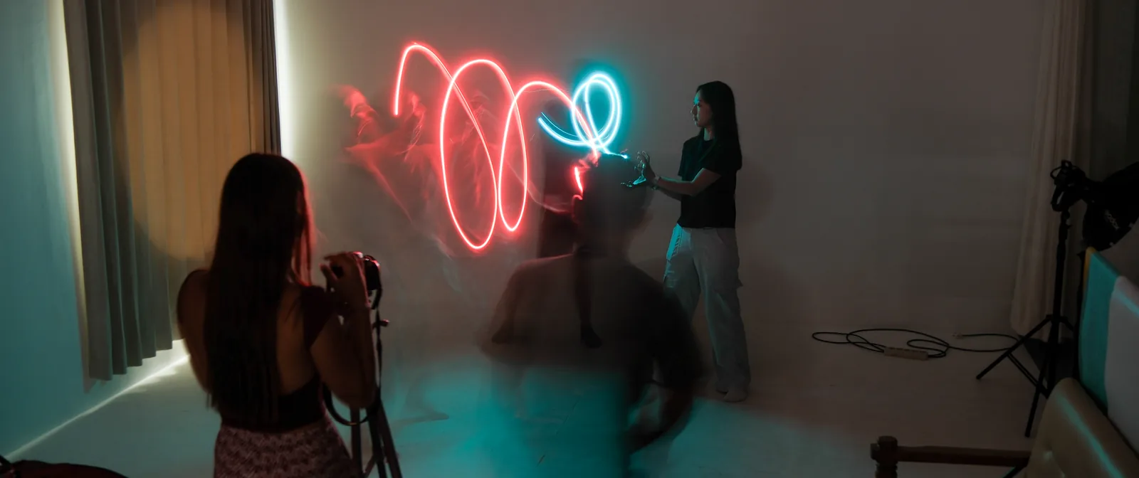 Students shooting a light-painting exercise in a darkened studio