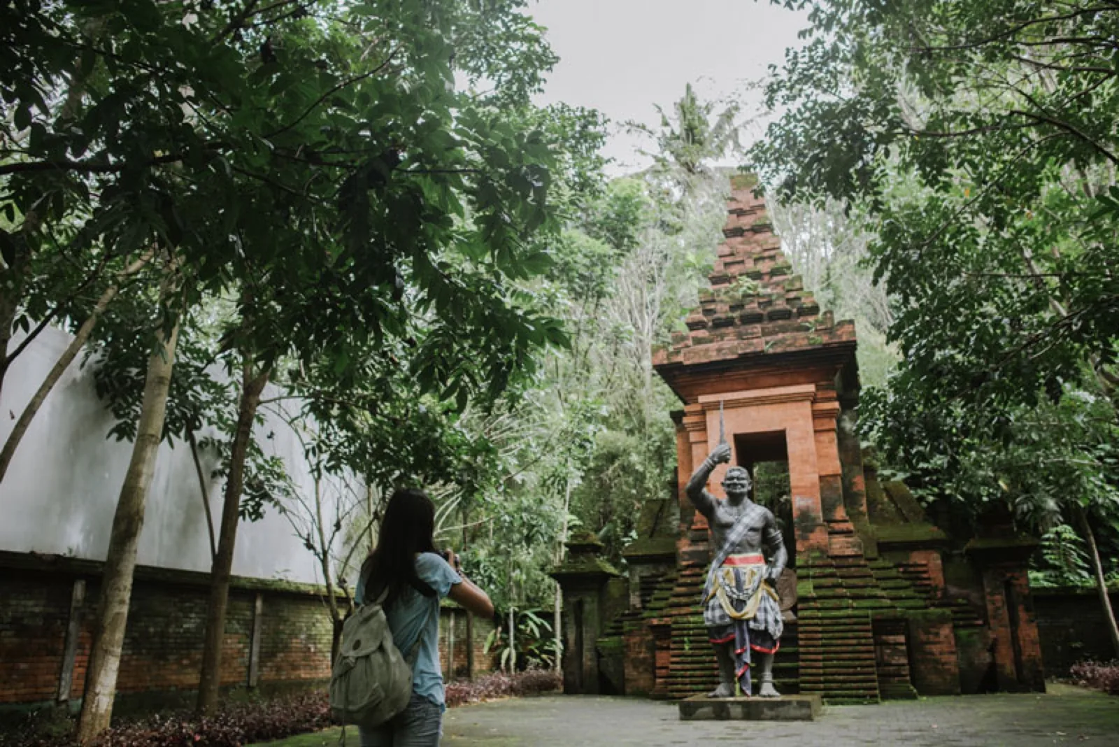 Student photographing a temple statue on an excursion day