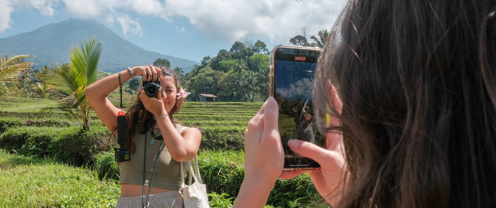 One student photographing the rice terraces while another films her