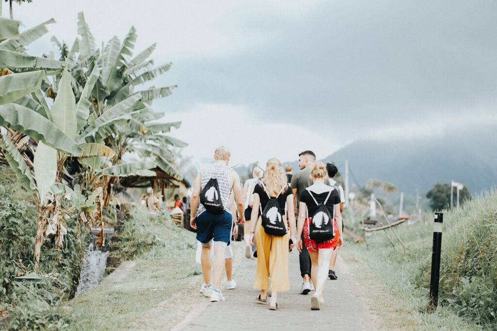 StudyInBali students on a field trip exploring the lush green rice fields of the Jatiluwih Rice Terraces, a UNESCO World Heritage Site in Bali.
