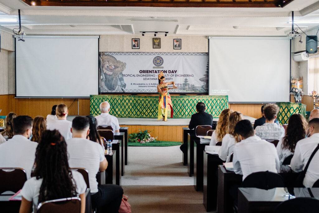 Students from the Southeast Asian Architecture and Southeast Asian Engineering study abroad programs at Universitas Udayana (UNUD) enjoying a traditional Balinese dance performance by a female dancer during orientation day